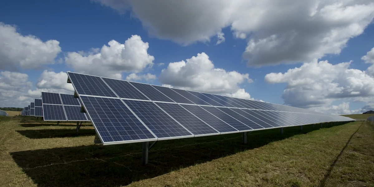 Solaranlage mit Windrädern bei Sonnenaufgang
