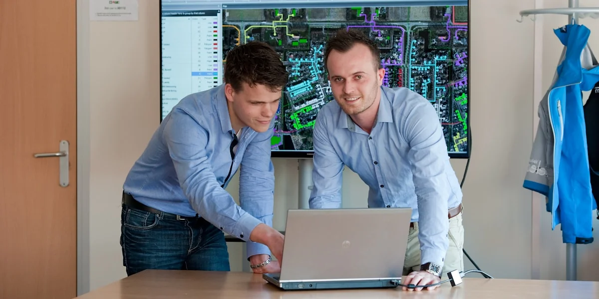 man in blue dress shirt using macbook pro