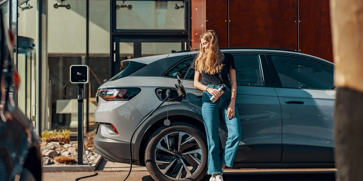 a woman standing next to a blue car