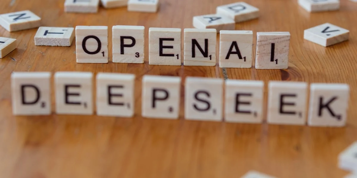 A wooden table topped with scrabble tiles spelling open and deep seek
