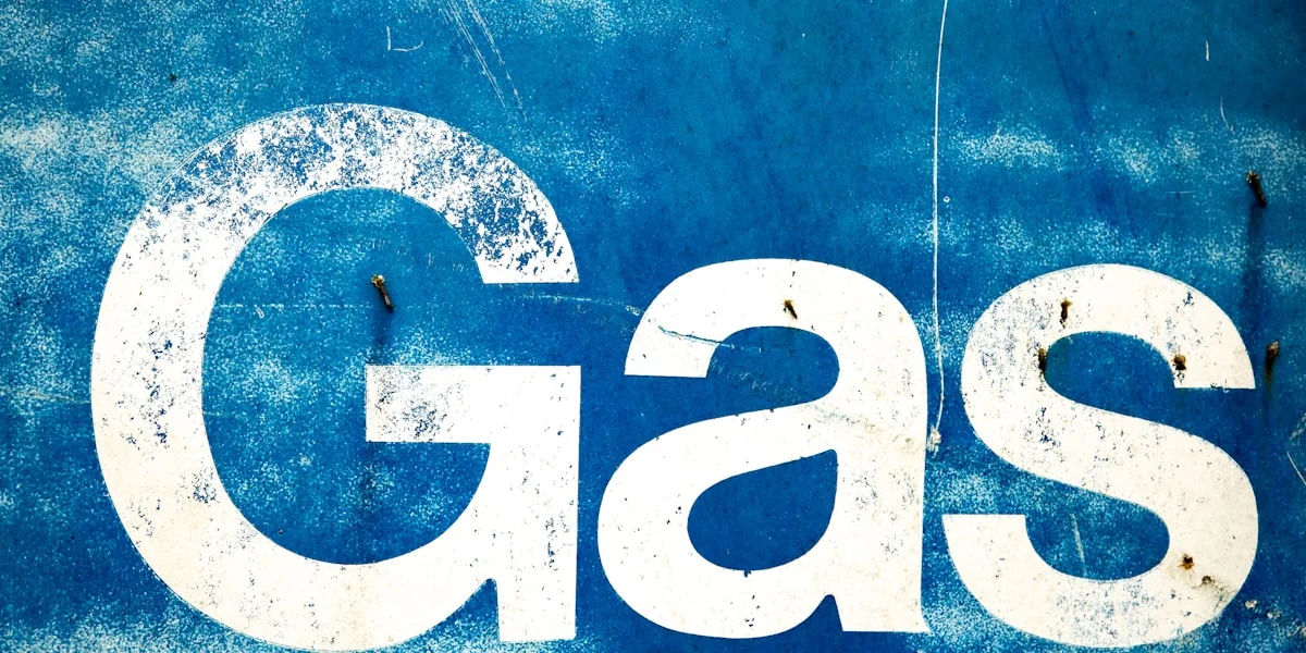 the word gas painted on the side of a blue wall