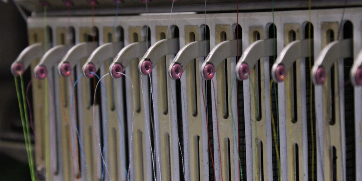 Close-up of an embroidery machine's thread guides.