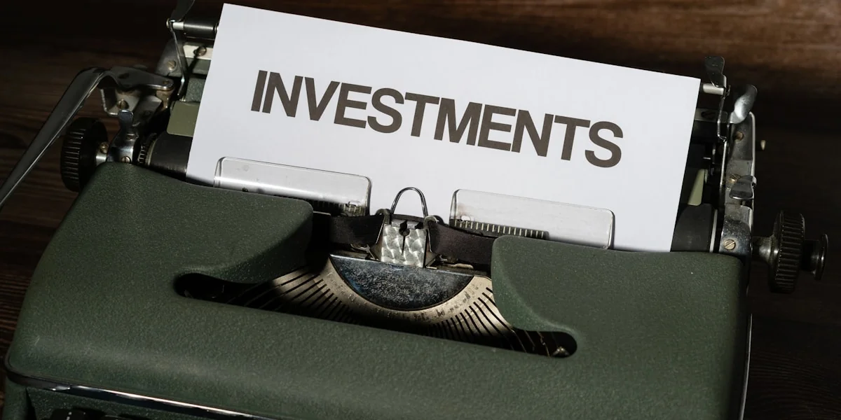 a close up of a typewriter with a paper that reads investments