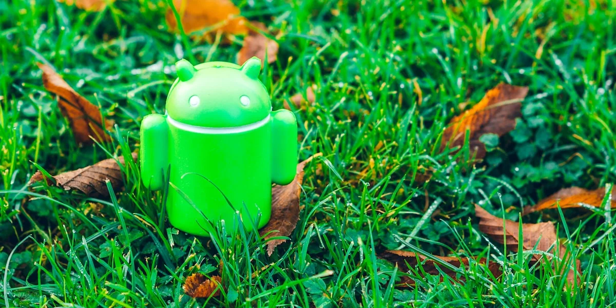green Android robot toy on grass