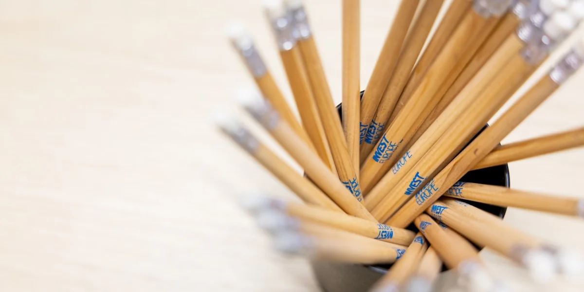 A cup filled with lots of pencils on top of a table