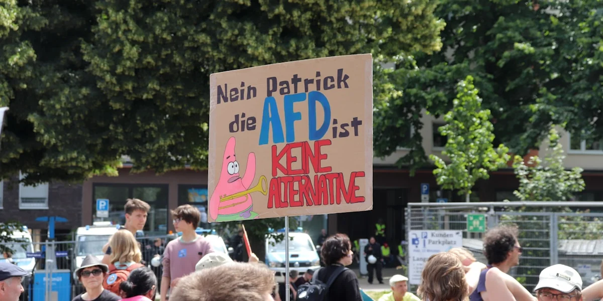 A group of people standing around each other holding signs