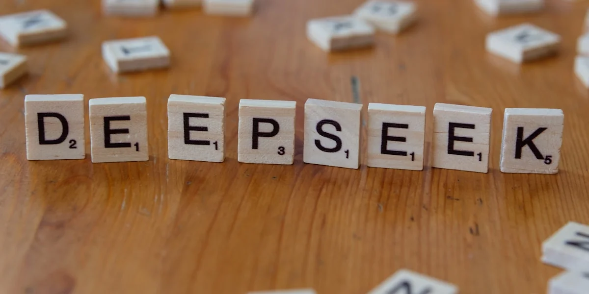 A wooden table topped with scrabble tiles spelling the word depeseek
