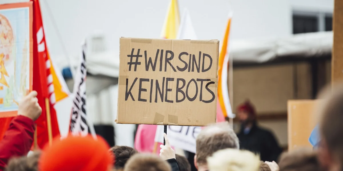 person raising wirsind keinebots signboard
