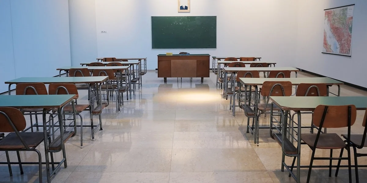Schüler und Lehrende im digitalen Zeitalter: Laptop mit KI-Interface in modernem Klassenzimmer