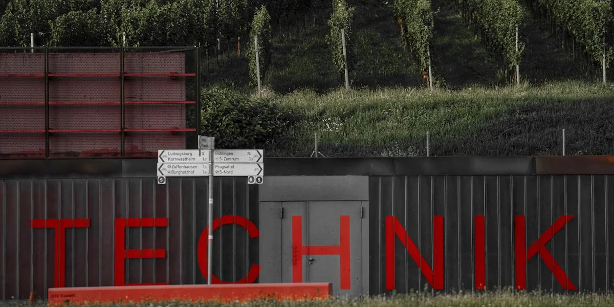 Red lettering spells out technik on a corrugated metal wall.