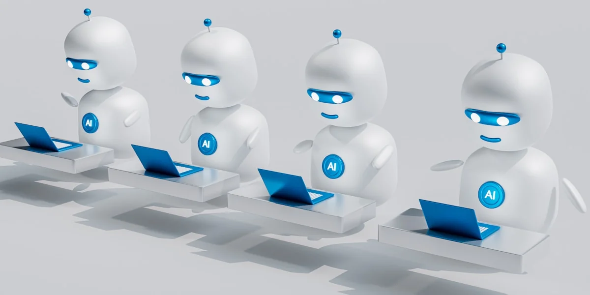 a group of white robots sitting on top of laptops