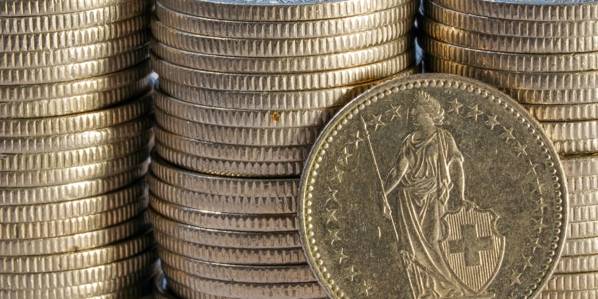 Stacks of gold coins with one coin in front.