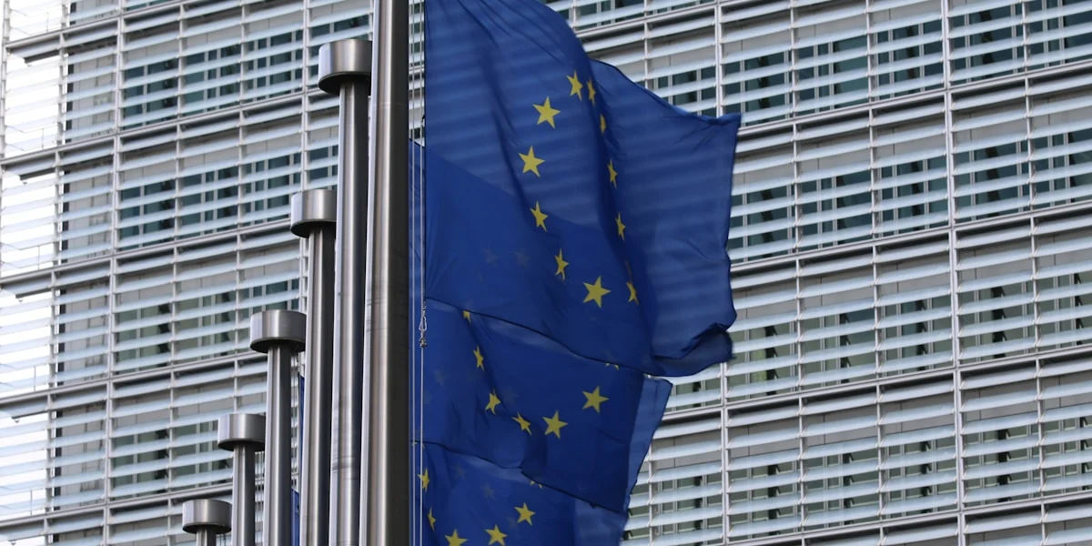 blue flag on pole near building during daytime