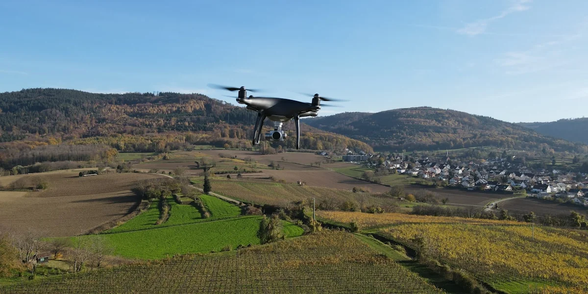 a small plane flying over a lush green hillside