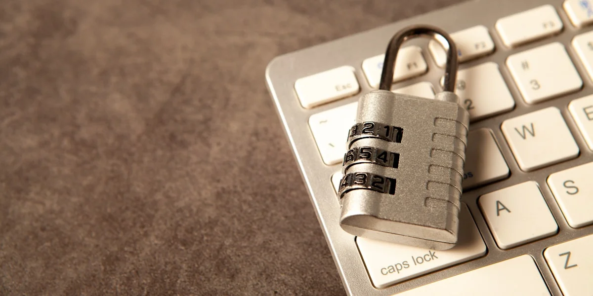 A padlock rests on a computer keyboard.