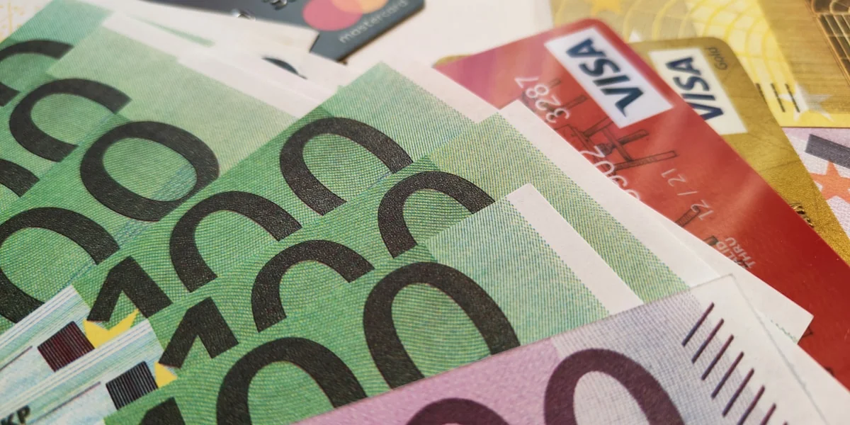 a pile of money with a credit card sticking out of it