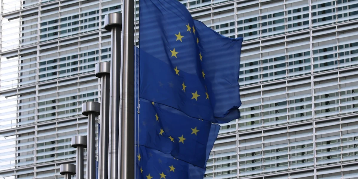 blue flag on pole near building during daytime