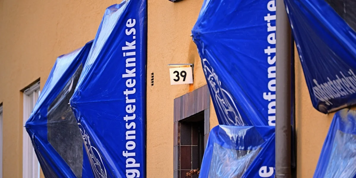 a group of blue umbrellas sitting on the side of a building