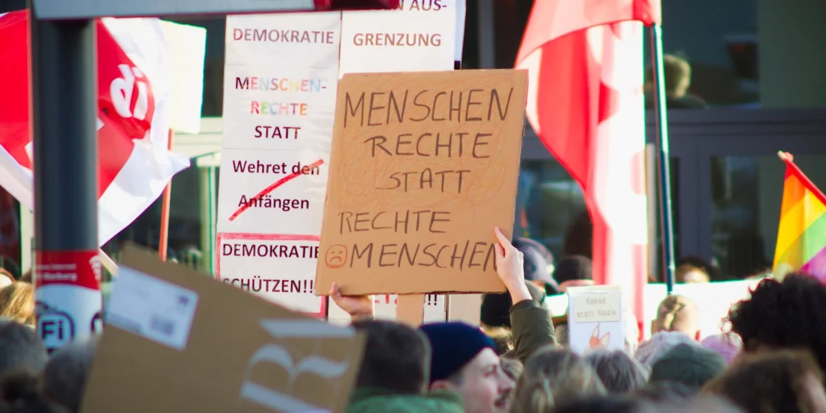 a crowd of people holding signs and flags