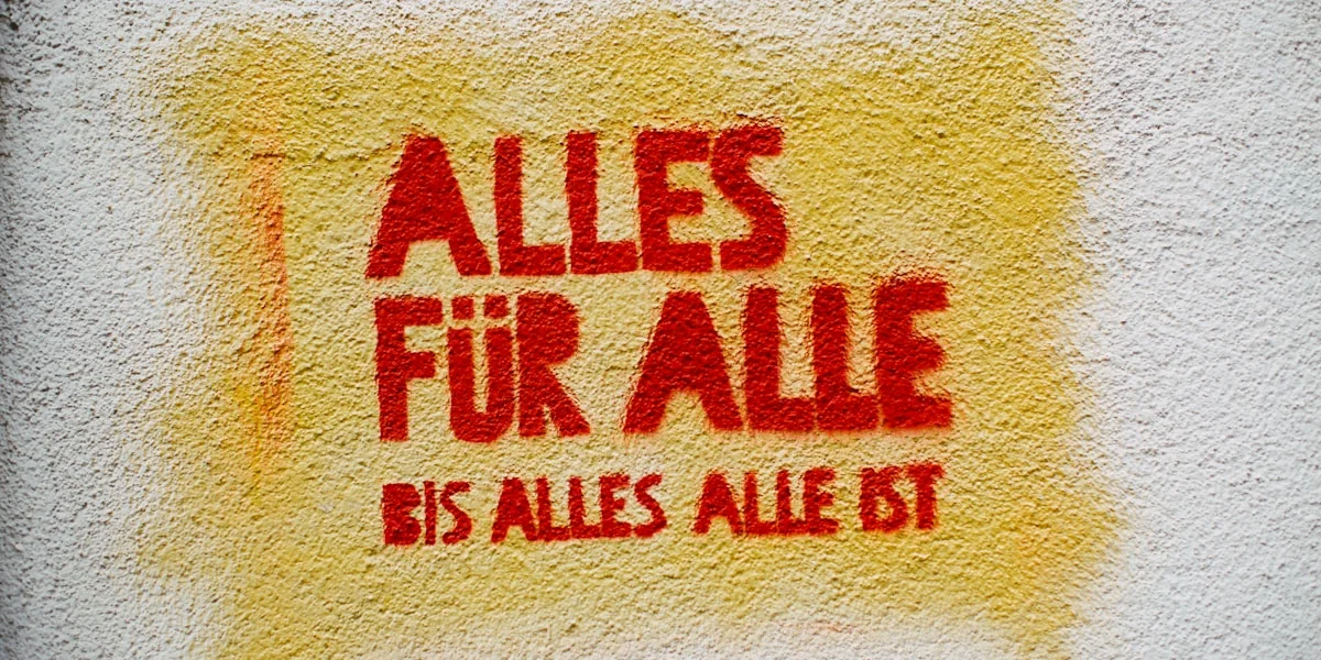 a yellow and red sign on a white wall