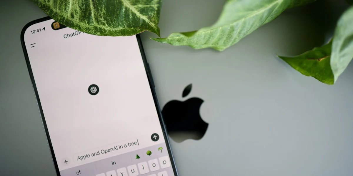 a cell phone sitting next to a green leaf