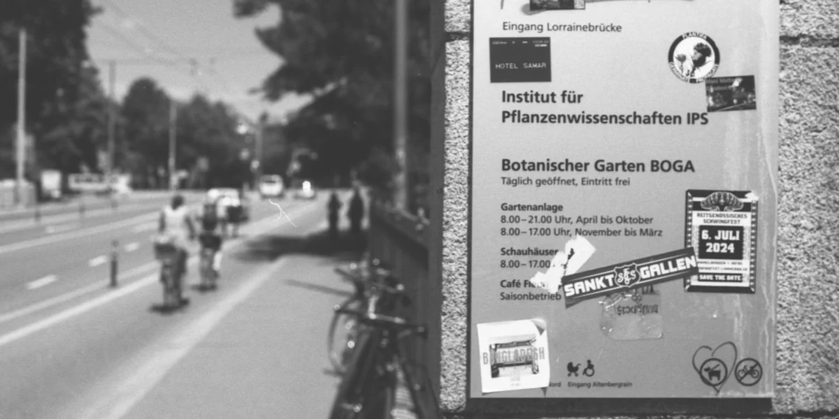 Sign for botanical garden with cyclists on road