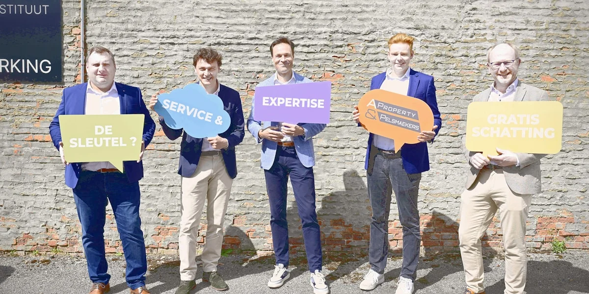Five men holding colorful speech bubble signs outdoors.