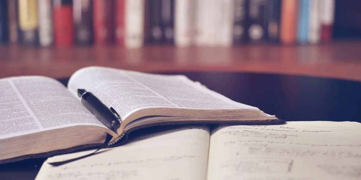 Person liest ein Buch über KI und Technologie an einem modernen Arbeitsplatz