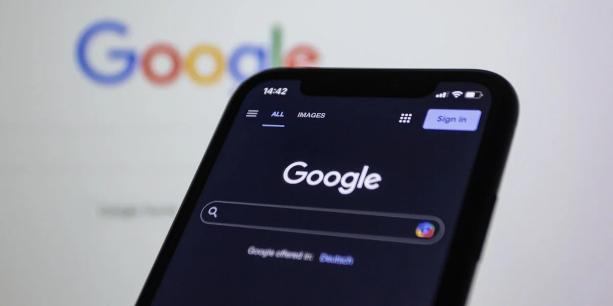 a close up of a cell phone with the google logo in the background