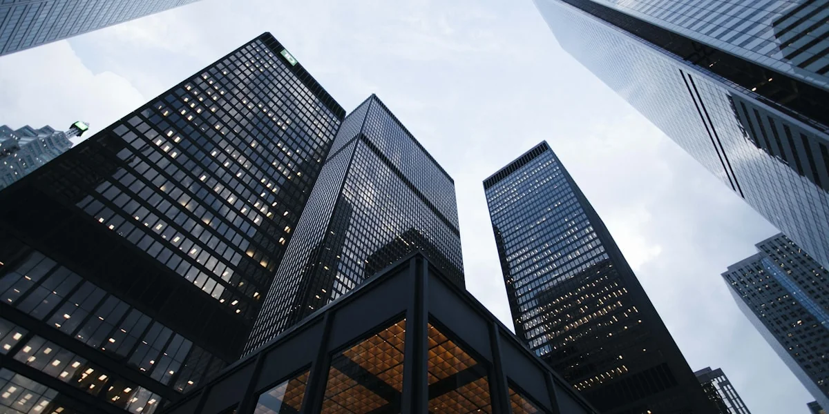 Wolkenkratzer der Wall Street bei Nacht mit beleuchteten Bürofenstern