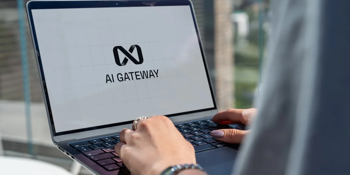 Person typing on laptop with ai gateway logo.