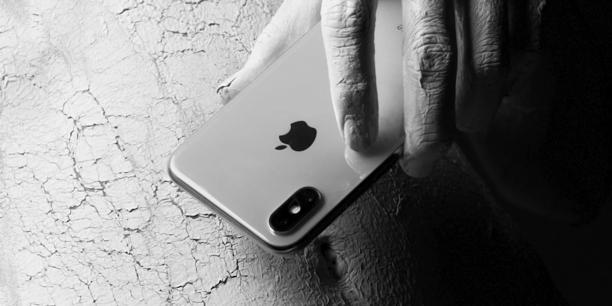 person holding iphone on black leather textile