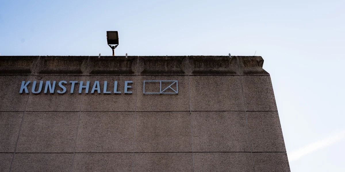 Concrete building with "kunsthalle" sign under sky