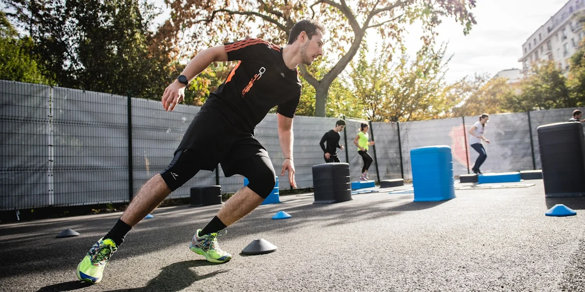 man in black and red nike crew neck t-shirt and black shorts running on gray