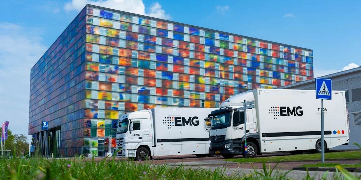 two trucks parked in front of a multi - colored building