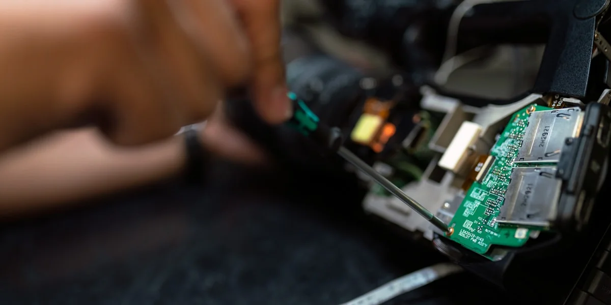 Reparatur eines elektronischen Geräts – Nahaufnahme von Werkzeug und Platine