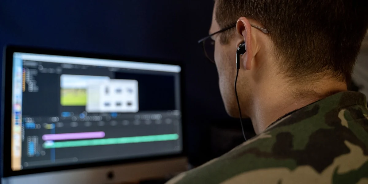 a man wearing headphones is looking at a computer screen