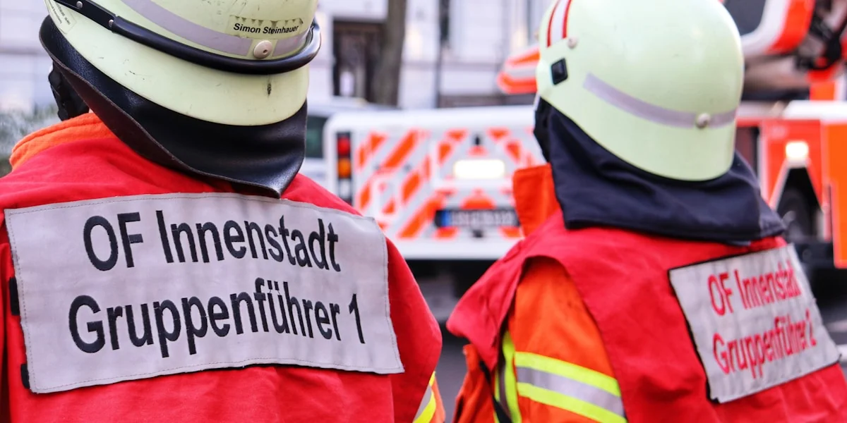 a couple of firemen standing next to each other